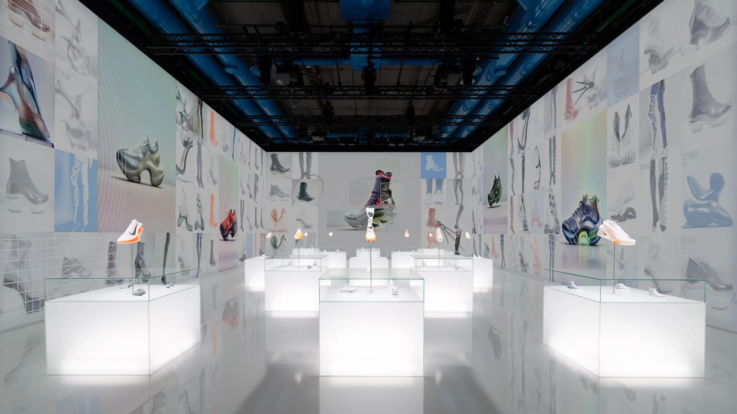 Exhibition room — Air prototypes in glowing vitrines surrounded by wall projections