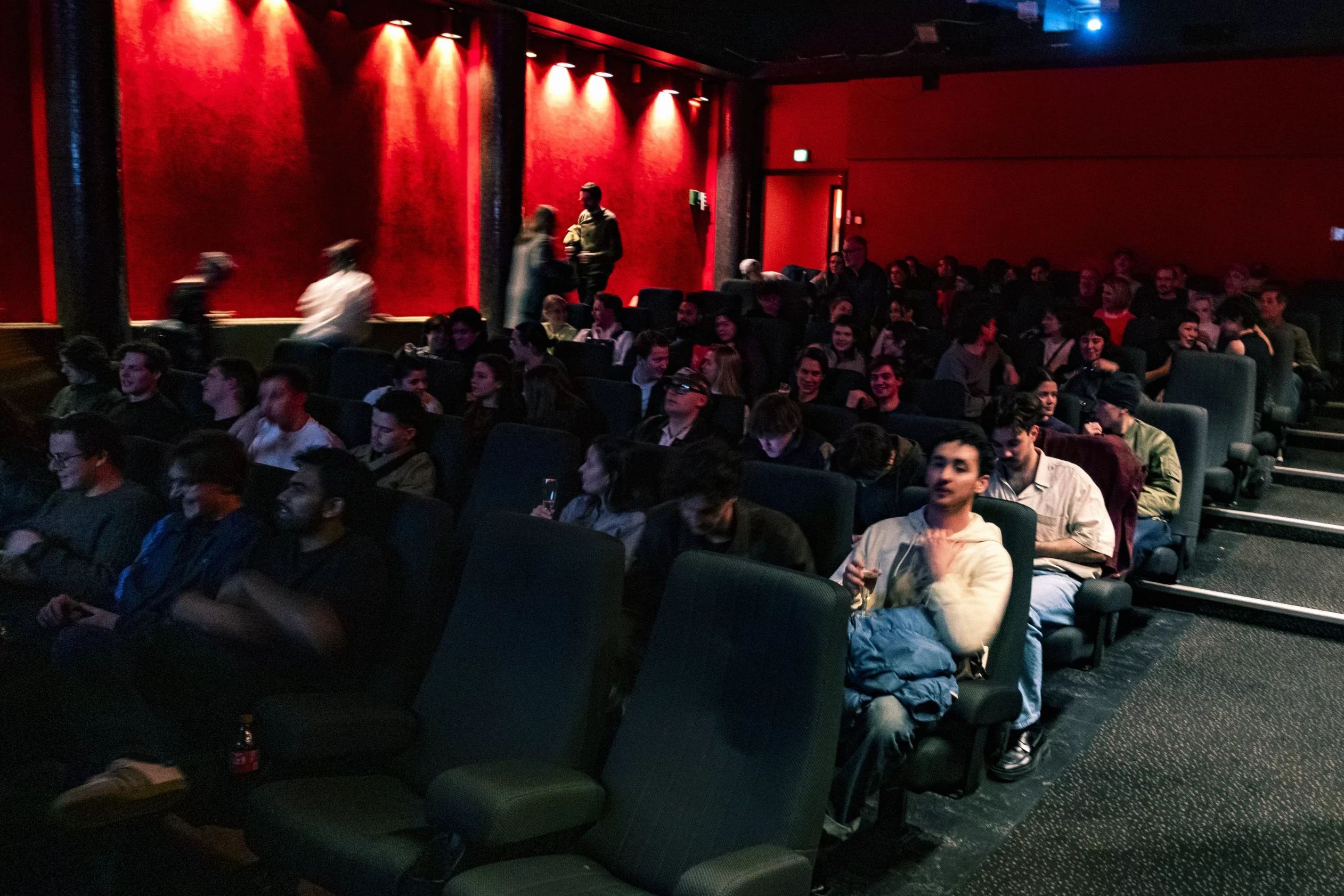 The audience settling into the red Cinerama screening room