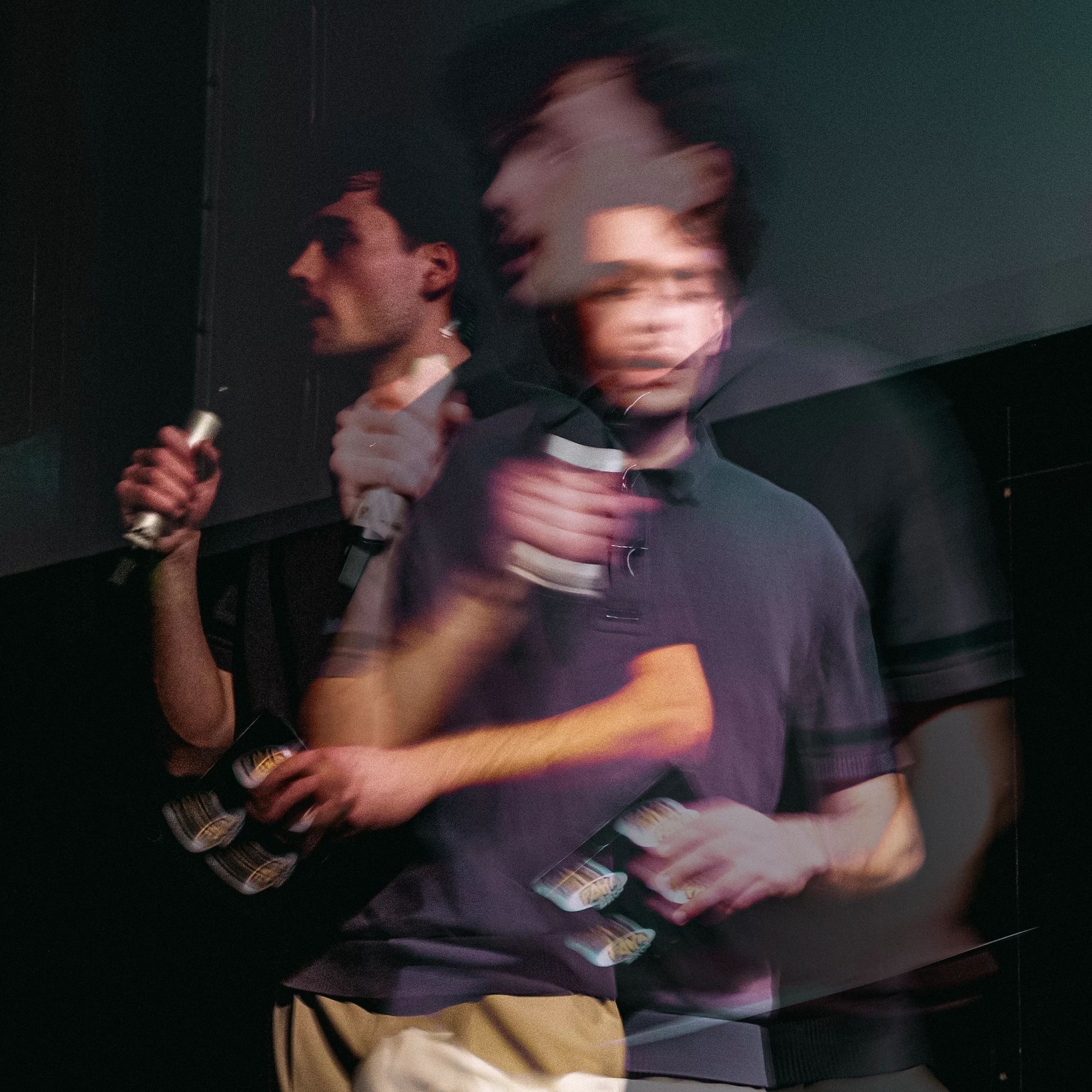 Double-exposure portrait on stage, microphone and Fanta cans in hand